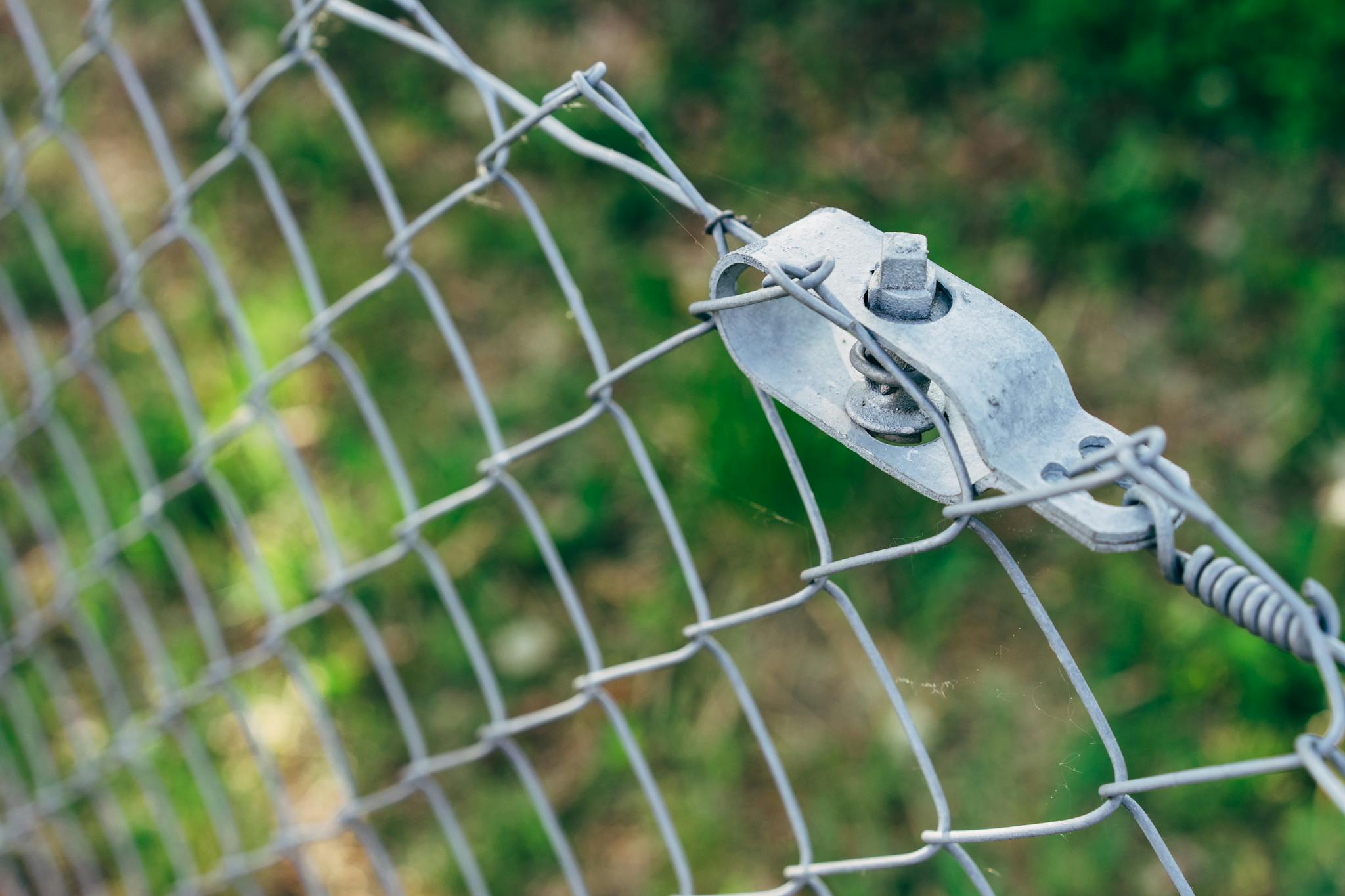 Detailed view of metal wire mesh fence with bolts for security and protection outdoors.